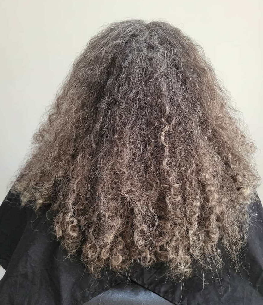 Loose blonde curls with an uneven, relaxed pattern.
