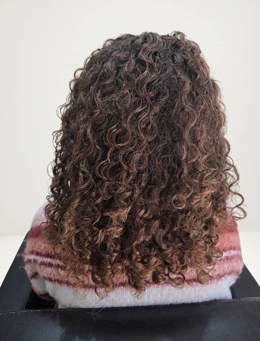 Dense curls with softer definition through the lengths.